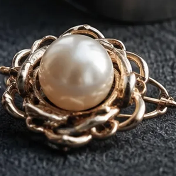 A gold brooch set with a large pearl.